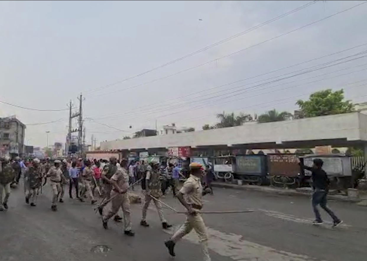 In this frame grab from video provided by KK Productions, police try to control a crowd shouting slogans during a protest soon after the killing of a tailor, Tuesday, June 28, 2022. Mobile internet services and large gatherings have been restricted in India’s western Udaipur city, a day after police arrested two Muslim men accused of killing a Hindu tailor in a suspected religious attack. The Hindu man, Kanhaiya Lal, was stabbed multiple times inside his tailoring shop Tuesday by two cleaver-wielding men who also filmed the attack, news agency Press Trust of India reported. (KK Productions via AP Photo)