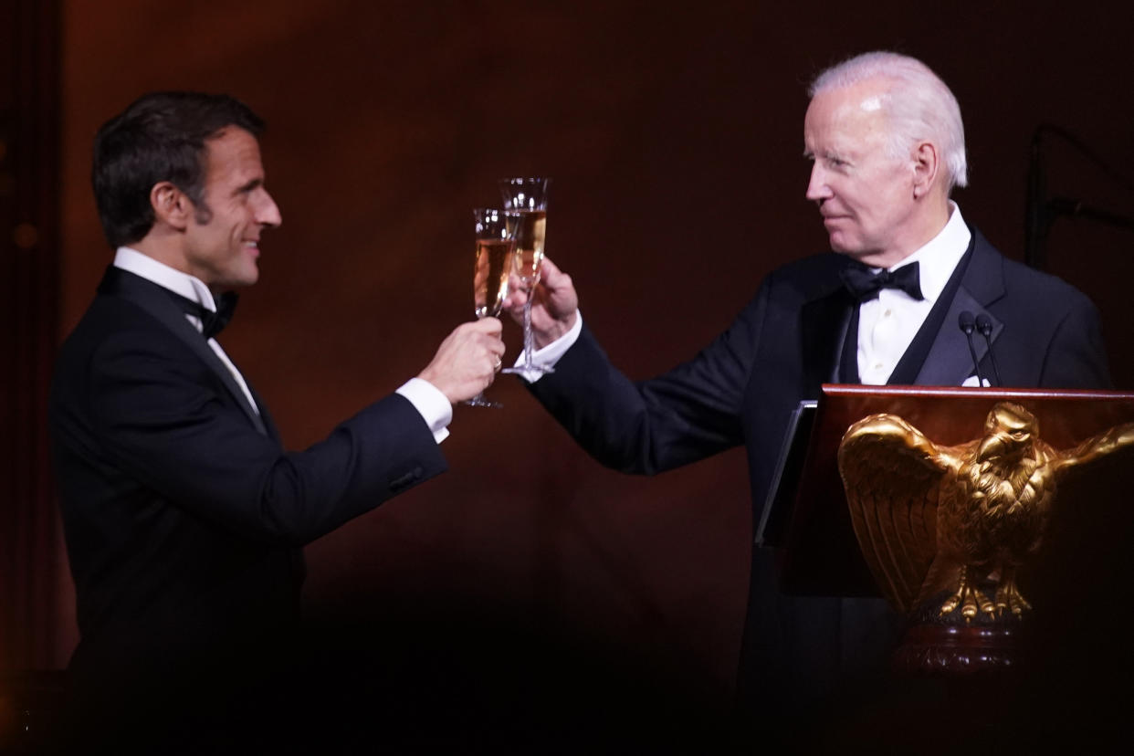 President Biden and French President Emmanuel Macron, in evening dress, toast during a state dinner.