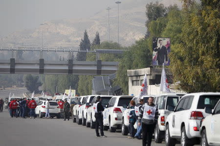 A convoy consisting of Red Cross, Red Crescent and United Nation (UN) gather before heading towards to Madaya from Damascus, and to al Foua and Kefraya in Idlib province, Syria January 11, 2016. REUTERS/Omar Sanadiki