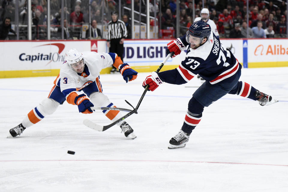 Washington Capitals left wing Conor Sheary (73) shoots the puck against New York Islanders defenseman Adam Pelech (3) during the second period of an NHL hockey game, Monday, April 10, 2023, in Washington. (AP Photo/Nick Wass)