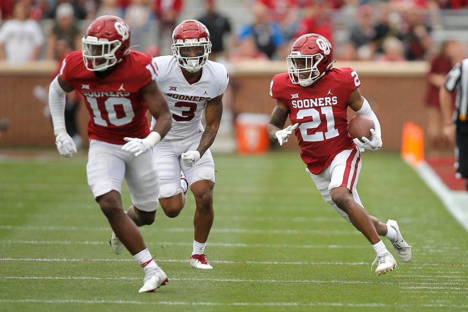 OU's Kendall Dennis (21) runs with the ball after an interception during Saturday's spring game.