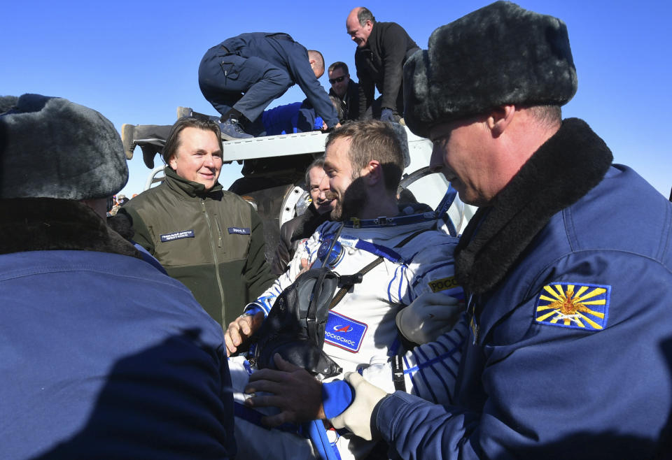 In this photo released by the Roscosmos Space Agency, film director Klim Shipenko, centre, speaks with Head of Russian First Channel Konstantin Ernst shortly after the landing of the Russian Soyuz MS-18 space capsule about 150 km (90 miles) south-east of the Kazakh town of Zhezkazgan, Kazakhstan, Sunday, Oct. 17, 2021. The Soyuz MS-18 capsule landed upright in the steppes of Kazakhstan on Sunday with cosmonaut Oleg Novitskiy, actress Yulia Peresild and film director Klim Shipenko aboard after a 3 1/2-hour trip from the International Space Station. (Pavel Kassin, Roscosmos Space Agency via AP)