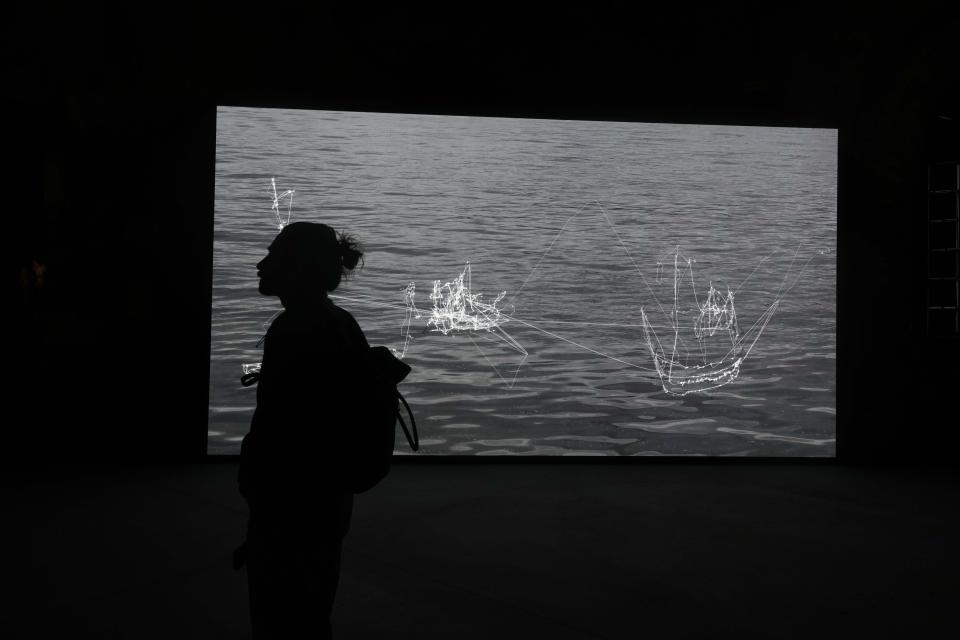 A visitor looks the installation "I Will Follow the Ship," by artist Matthew Attard at the Malta pavilion at the 60th Biennale of Arts exhibition in Venice, Italy, Tuesday, April 16, 2024. The Venice Biennale contemporary art exhibition opens Saturday for its six-month run through Nov. 26. (AP Photo/Luca Bruno)