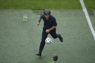 Germany's manager Joachim Loew collects the ball during the Euro 2020 soccer championship group F match between Portugal and Germany at the football arena stadium in Munich, Saturday, June 19, 2021. (Matthias Hangst/Pool Photo via AP)