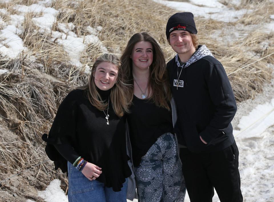 Aria Amos, 16, left, her sister Bella, 18, and brother Austin, 17, pose for a photo at Hampton Beach, where the three live together in a seasonal rental after losing both parents within a year of each other.