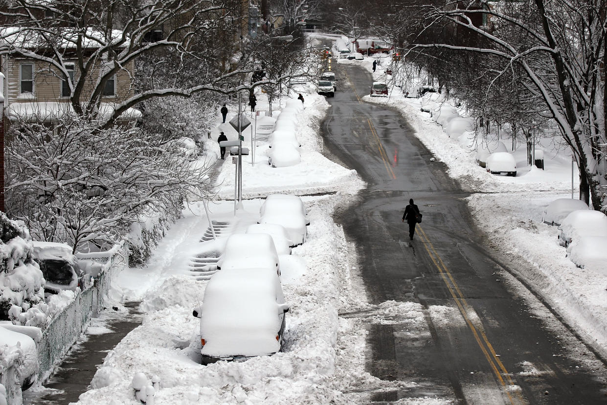 A man walks down a snowy street in Brooklyn in January 2011.