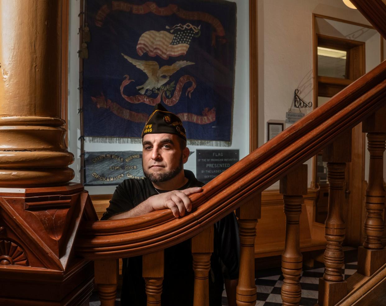 Marine Cpl. Eric Calley of Williamston stands by a Civil War battle flag of the 21st Michigan Infantry, which hangs inside the Ionia County Courthouse, as seen on Tuesday, Feb. 27, 2024.