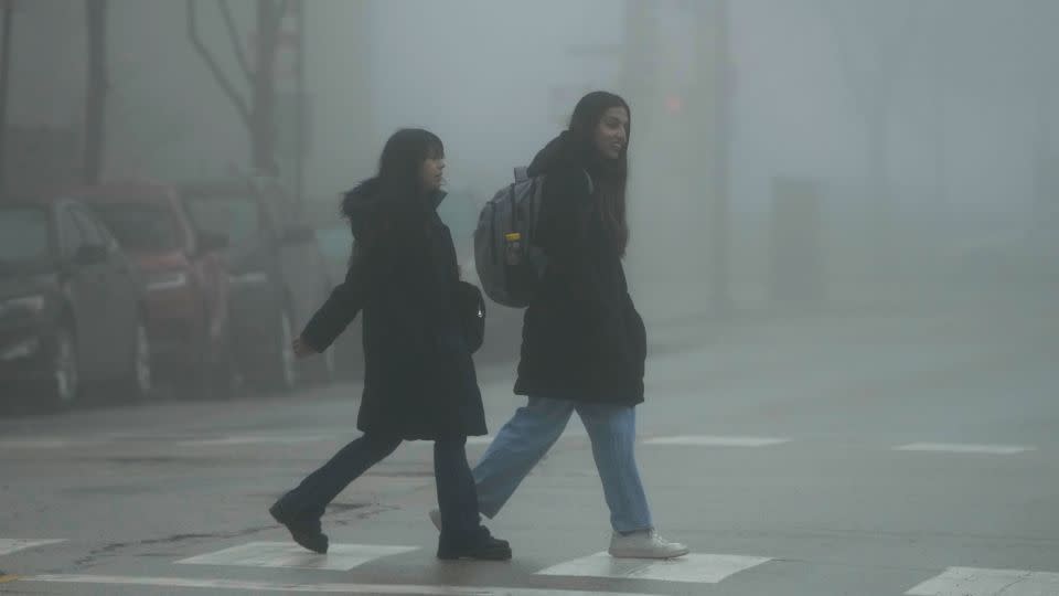 Pedestrians cross a street in the fog on Thursday, Jan. 25, 2024., in Chicago. - Nam Y. Huh/AP