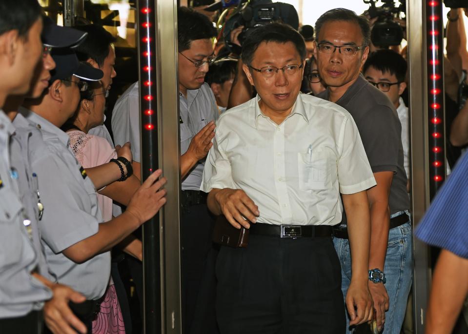 Taipei Mayor Ke Wen-che is escorted by security staff upon arriving at the Taipei District Prosecutors Office on July 28, 2015.  Ke is accused by Lo Shu-lei, a legislator from the ruling Kuomintang (KMT) for illegal setting of bank accounts during the Taipei mayor elections in 2014.    AFP PHOTO  / Sam YEH        (Photo credit should read SAM YEH/AFP/Getty Images)