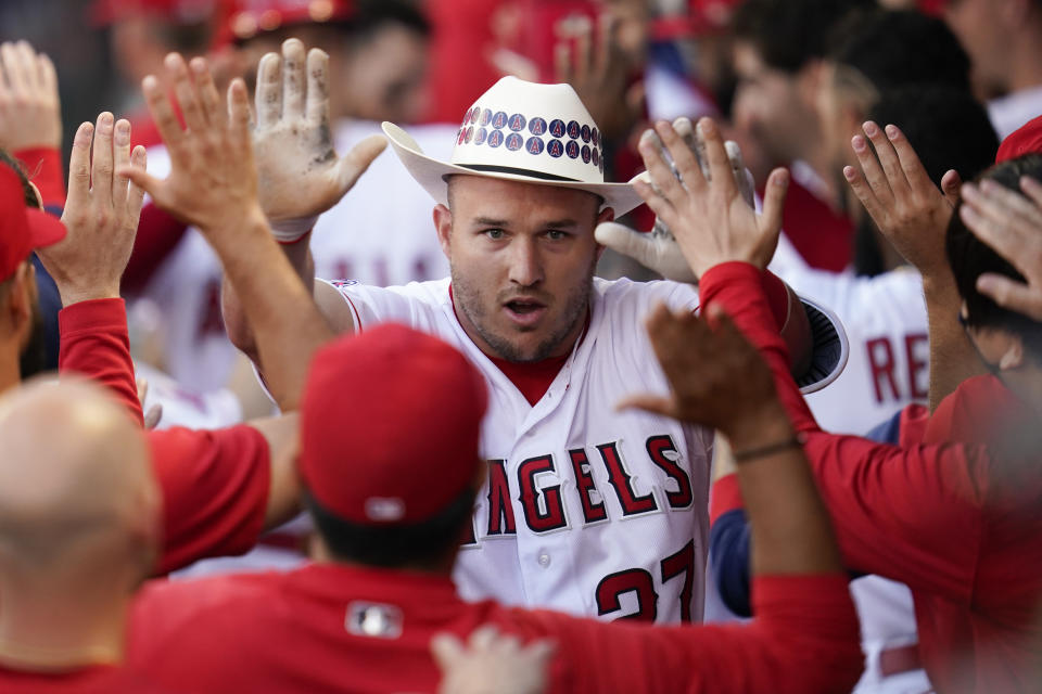 Los Angeles Angels' Mike Trout (27) celebrates in the dugout after hitting a home run during the first inning of a baseball game against the Boston Red Sox in Anaheim, Calif., Tuesday, June 7, 2022. Shohei Ohtani also scored. (AP Photo/Ashley Landis)