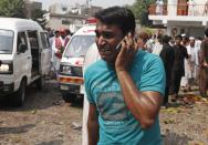 A man uses his mobile phone as he mourns the death of his relatives at the site of a blast at a church in Peshawar September 22, 2013. A pair of suicide bombers blew themselves up outside the church in the Pakistani city of Peshawar, killing 40 people after Sunday mass, security officials said. REUTERS/Fayaz Aziz (PAKISTAN - Tags: RELIGION CIVIL UNREST)