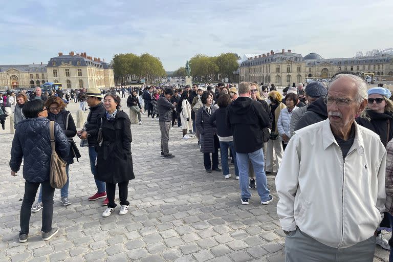 Turistas esperan afuera del Palacio de Versalles el martes 17 de octubre de 2023 en Versalles, Francia. 