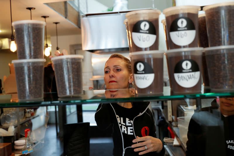 FILE PHOTO: Amy Hillyard, owner of Farley’s East cafe stocks coffee to be given to laid off employees at the cafe in Oakland, California