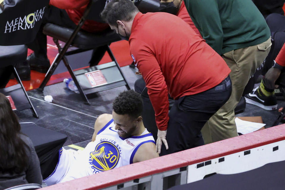 Golden State Warriors' Stephen Curry after falling into the Houston bench