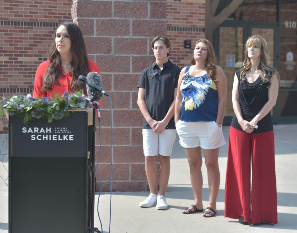 Members of Karen Garner's family, from left, grandson Drew Steward, daughter-in-law Shannon Steward and daughter Allisa Swartz look on as attorney Sarah Schielke announces they have reached a $3 million settlement with the city of Loveland and its police department to end a federal civil rights lawsuit during a news conference Wednesday, Sept. 8, 2021, in front of the Loveland Police and Courts building in Loveland, Colo.