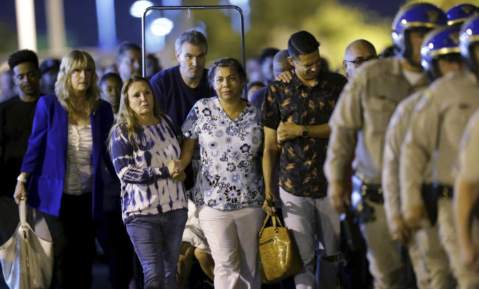 Slain California Highway Patrol officer Andre Moye is transported to a hearse as his family follows from the Riverside University Health Systems Medical Center after he was shot and killed while two fellow officers were wounded during a traffic stop on Eastridge Avenue overpass over the 215 Freeway in Moreno Valley on Monday, Aug 12, 2019. (Terry Pierson/The Orange County Register via AP)