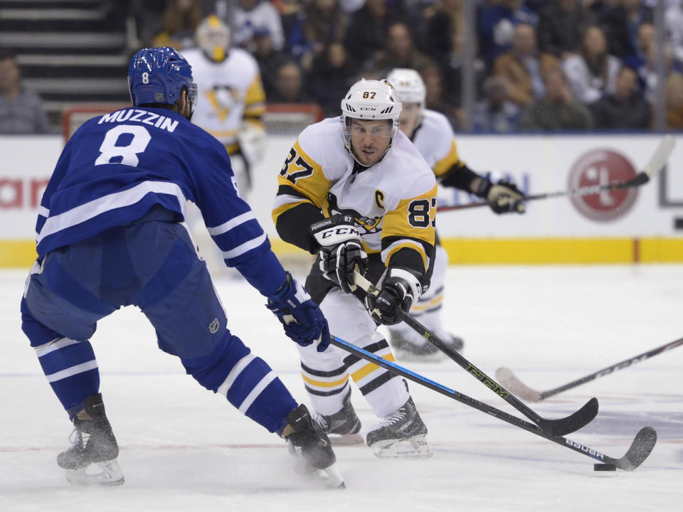 Pittsburgh Penguins center Sidney Crosby (87) and Toronto Maple Leafs defenseman Jake Muzzin (8) vie for the puck during the first period of an NHL hockey game Thursday, Feb. 20, 2020, in Toronto. (Nathan Denette/The Canadian Press via AP)