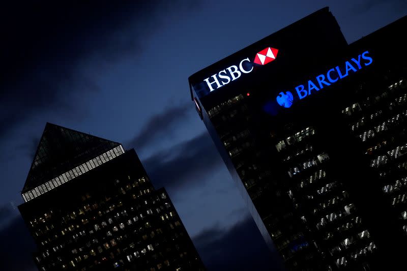 FILE PHOTO: HSBC and Barclay's buildings are lit up at dusk in the Canary Wharf financial district of London