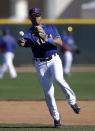 Seattle Seahawks quarterback Russell Wilson throws to first after fielding ground ball at second with the Texas Rangers during spring training baseball practice, Monday, March 3, 2014, in Surprise, Ariz. (AP Photo/Tony Gutierrez)