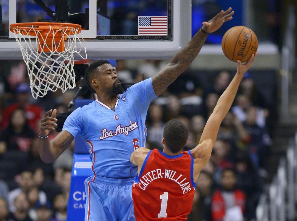 Los Angeles Clippers center DeAndre Jordan, left, rejects a shot by Philadelphia 76ers guard Michael Carter-Williams during the first half of an NBA basketball game Sunday, Feb. 9, 2014, in Los Angeles. (AP Photo/Mark J. Terrill)