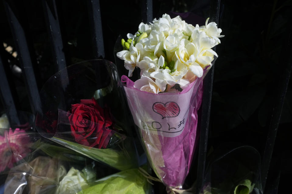 A bunch of flowers with a note reading "Lola" is laid outside the building where the body of 12-year-old schoolgirl was discovered in a trunk, in Paris, Wednesday, Oct. 19, 2022. France has been "profoundly shaken" by the murder of a 12-year-old schoolgirl, whose body was found in a plastic box, dumped in a courtyard of a building in northeastern Paris, the government spokesman Olivier Veran said on Wednesday. (AP Photo/Michel Euler)