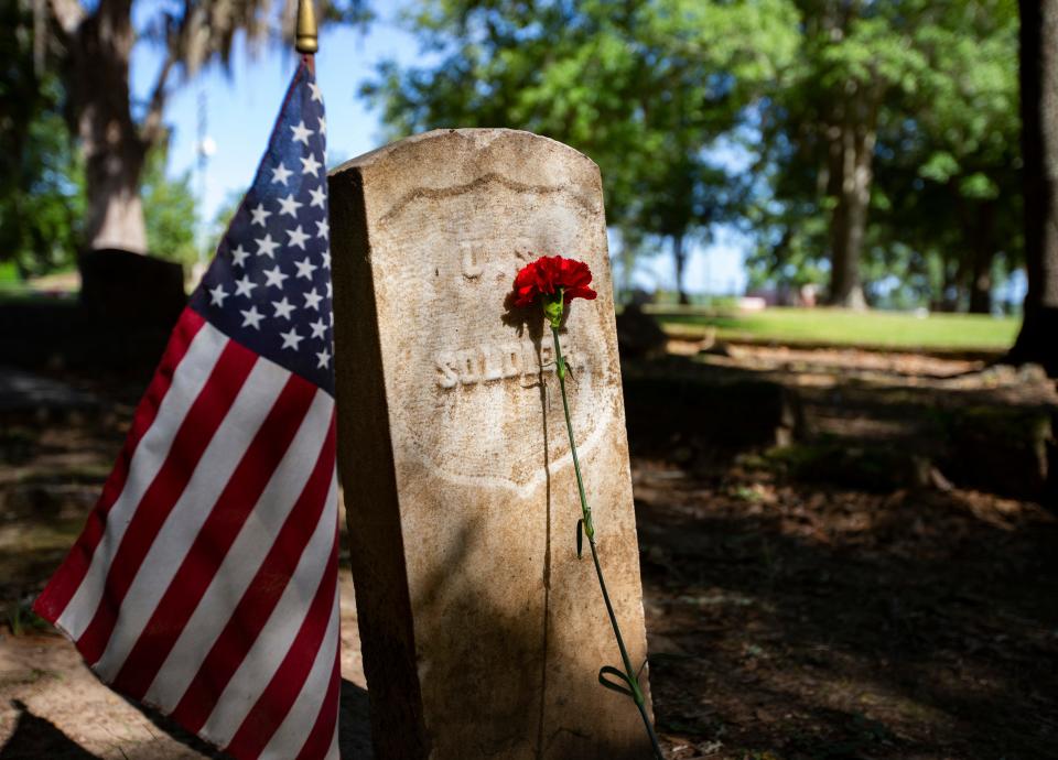 Students from Bethel Christian Academy and Kingdom of Life Preparatory Academy lay red carnations by gravestones in the Old City Cemetery during an Emancipation Day Commemoration hosted by the John G. Riley Museum Thursday, May 20, 2021. 