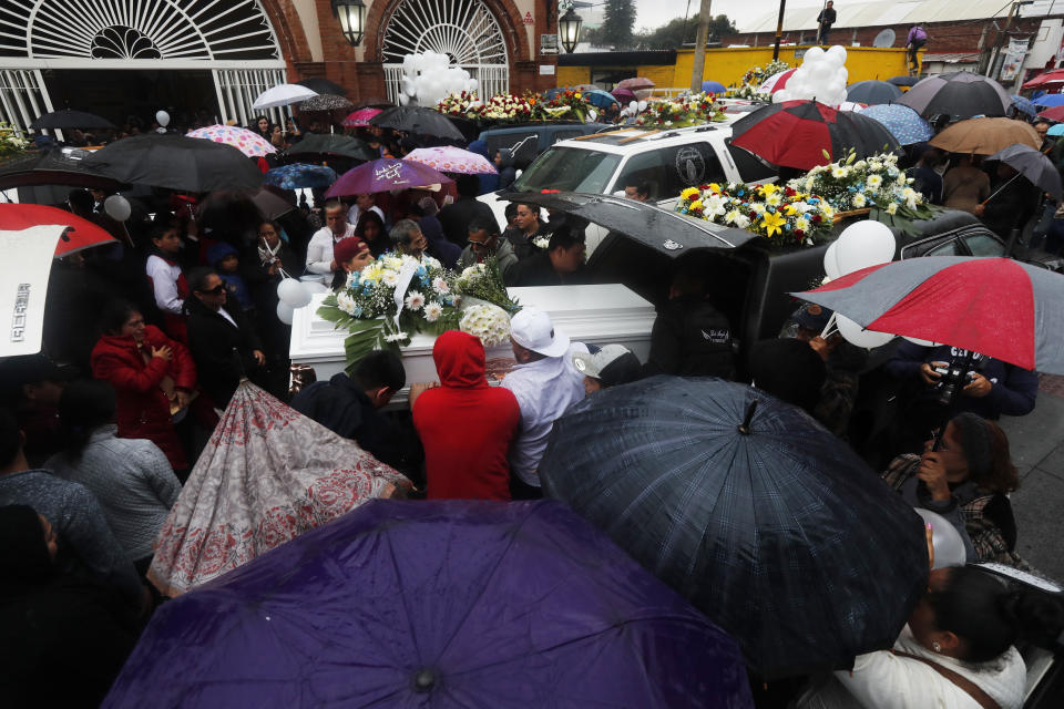 In this Feb. 5, 2020 photo, family and friends place the coffin of one of the victims shot dead in a video-game arcade, into a hearse during a funeral procession in Uruapan, Mexico. Uruapan, a city of about 340,000 people, is in Mexico's avocado belt, where violence has reached shocking proportions. In Uruapan, cartels are battling for territory and reports of killings are common, such as the gun massacre last week of three young boys, a teenager and five others at an arcade in what had been a relatively quiet neighborhood. (AP Photo/Marco Ugarte)