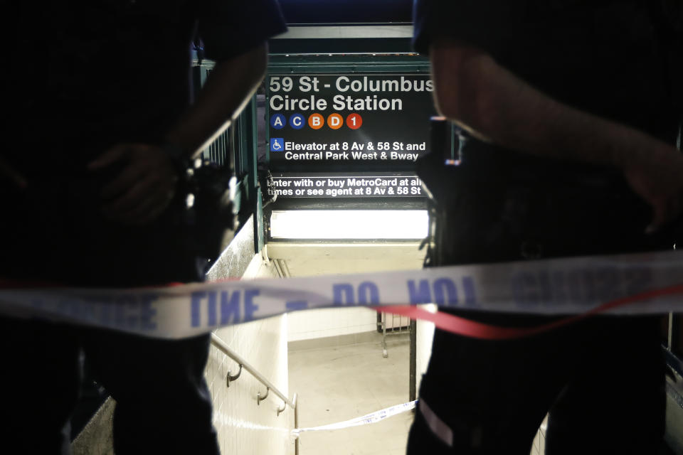 Police officers stand guard at a closed subway station during a power outage Saturday, July 13, 2019, in New York. (AP Photo/Michael Owens)