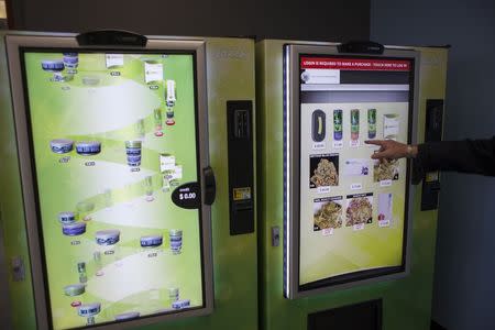 Stephen Shearin demonstrates the use of a ZaZZZ vending machine that contains cannabis flower, hemp-oil energy drinks, and other merchandise at Seattle Caregivers, a medical marijuana dispensary, in Seattle, Washington February 3, 2015. REUTERS/David Ryder