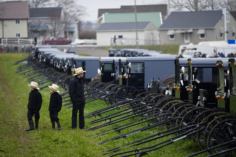 Youths look at buggies that will be auctioned off during the 56th annual mud sale to benefit the local fire department in Gordonville, Pa., Saturday, March 9, 2024. Mud sales are a relatively new tradition in the heart of Pennsylvania's Amish country, going back about 60 years and held in early spring as the ground begins to thaw but it's too early for much farm work. (AP Photo/Matt Rourke)