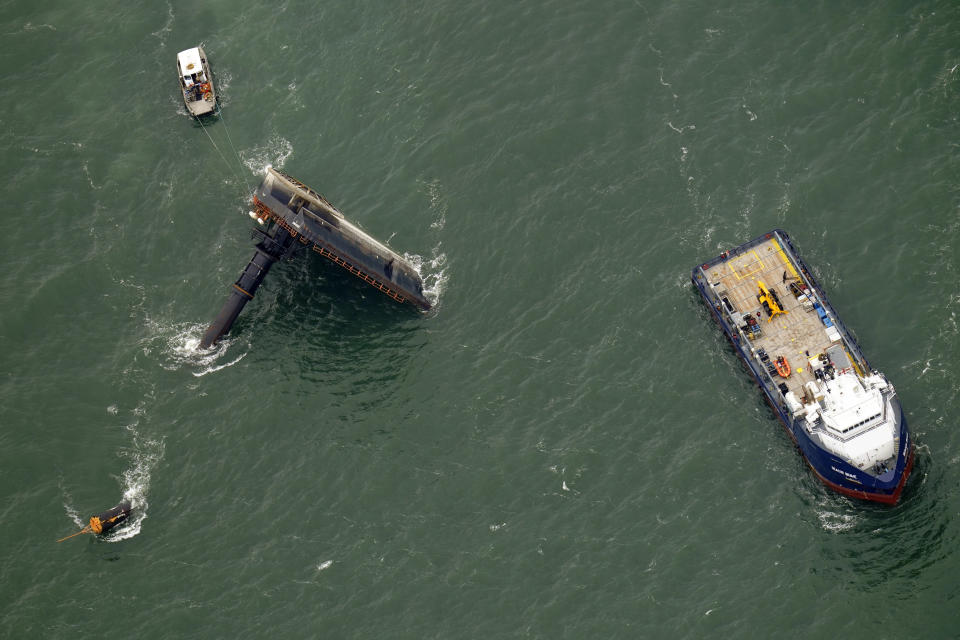 FILE- In this April 18, 2021, file photo, rescue boats are seen next to the capsized lift boat Seacor Power, left, seven miles off the coast of Louisiana in the Gulf of Mexico. The lift boat had lowered its legs and was trying to turn to face heavy winds when it flipped in the Gulf of Mexico off Louisiana last month, according to a preliminary federal report released Tuesday, May 18, 2021. (AP Photo/Gerald Herbert, File)