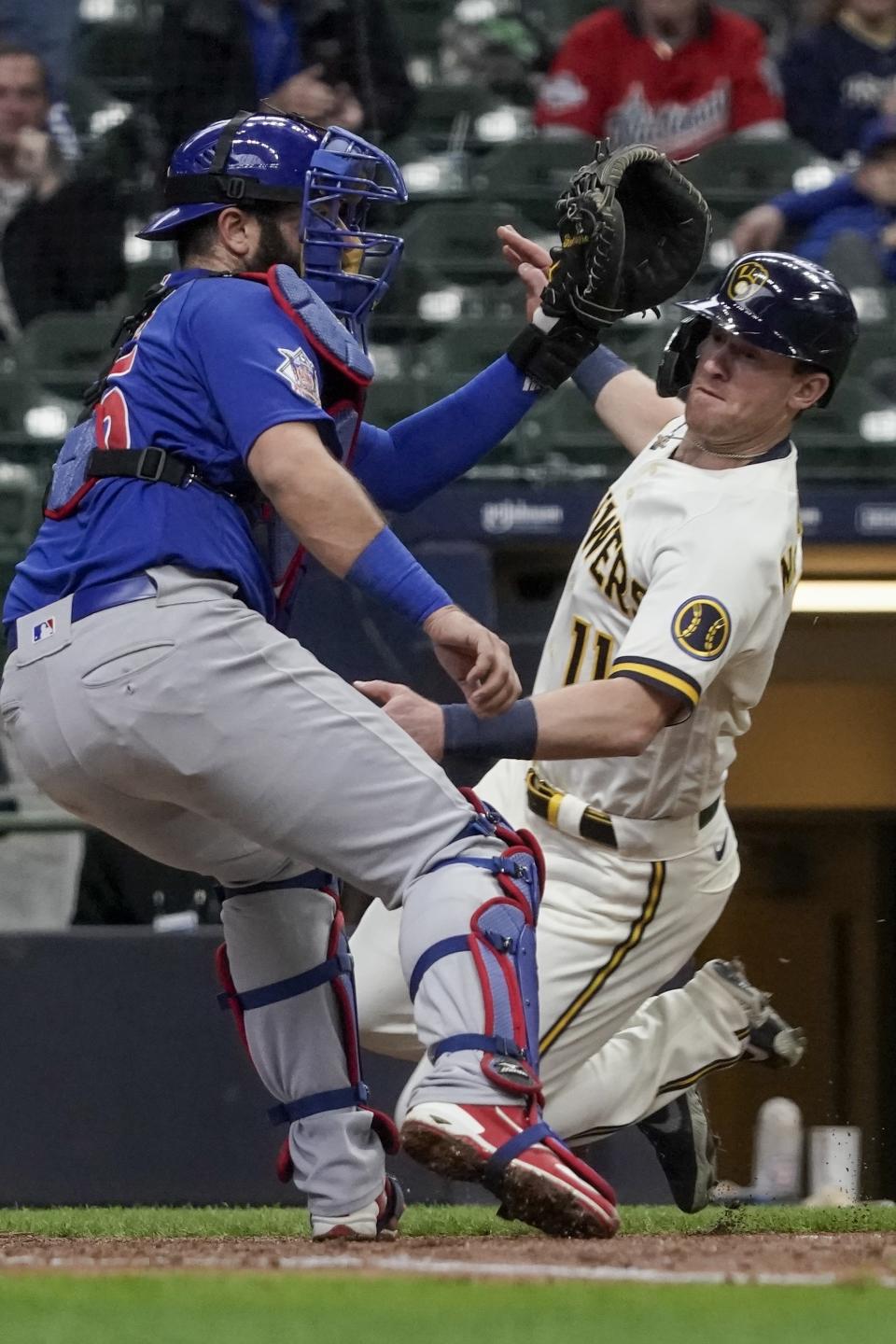 Milwaukee Brewers' Billy McKinney slides safely past Chicago Cubs catcher Austin Romine during the sixth inning of a baseball game Wednesday, April 14, 2021, in Milwaukee. McKinney scored from second on a hit by Corbin Burnes. (AP Photo/Morry Gash)