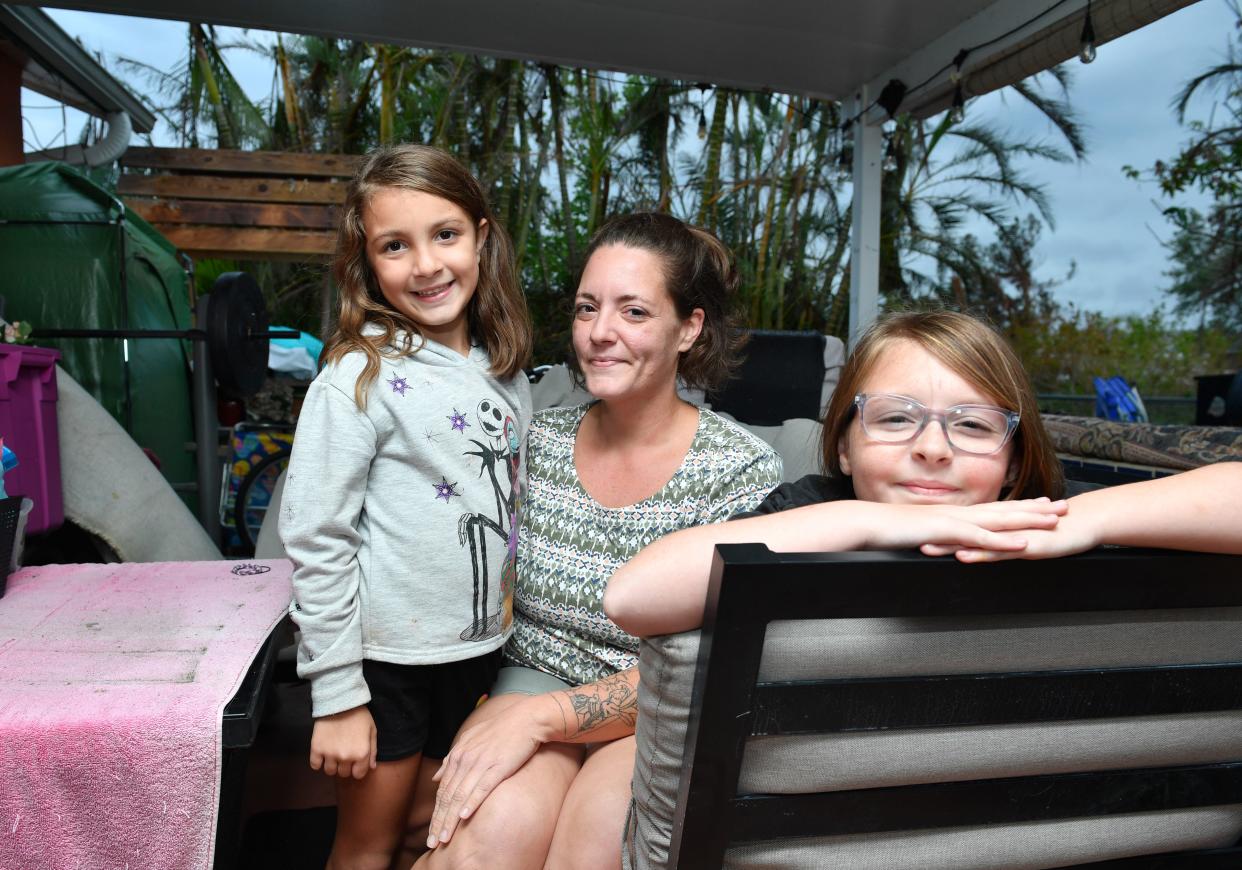 Kayla Yenna, with her daughters, Charlotte, 7,left, and Ashlyn, 12, right. After their rental home got flooded from Hurricane Ian, the owner declared the house unlivable and told her she was on her own. She and her daughters are now living in her mother's three-bedroom Englewood house, along with her sister and her family. Their stuff is in a tent outside.