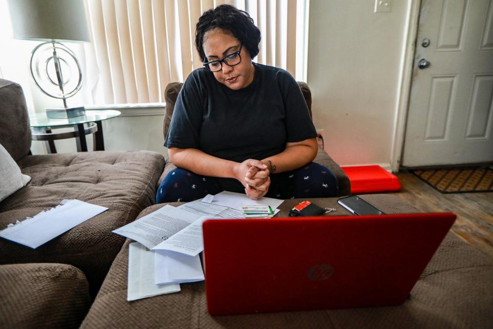 Christanine Brodis, 48, of Detroit talks on the phone with a representative from the Accounting Aid Society to help her file her 2020 taxes at her home on Feb. 13, 2021. Brodis lost her job as a personal home care provider and is struggling to get a tax refund from last year and she did not get one of her stimulus checks.