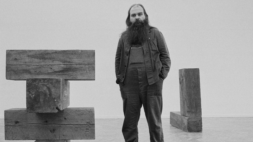 American artist and sculptor Carl Andre pictured at London's Whitechapel Gallery in London on March 15, 1978. Andre’s work often consisted of industrially fabricated forms made from simple, raw material — such as metal, granite, wood, and brick — arranged in free-standing patterns. - Evening Standard/Getty Images