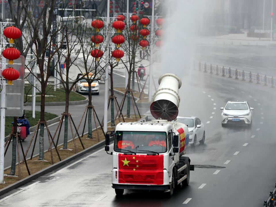 Workers operate a vehicle to carry out disinfection in Jianghan district_China Daily via Reuters.JPG