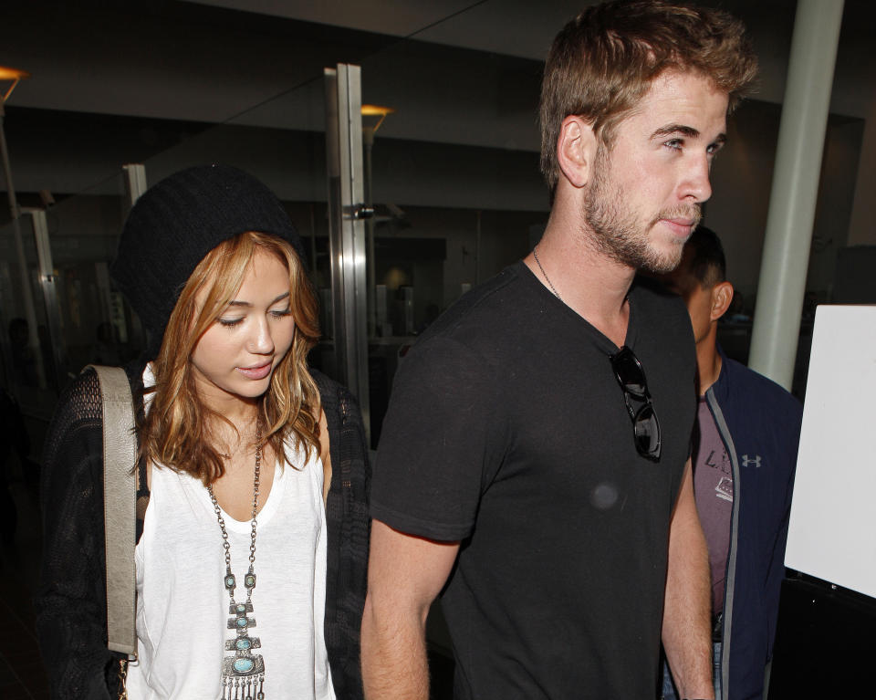 Miley Cyrus and Liam Hemsworth arrive at LAX airport on June 21, 2010 in Los Angeles, California. (Photo by Jean Baptiste Lacroix/WireImage)
