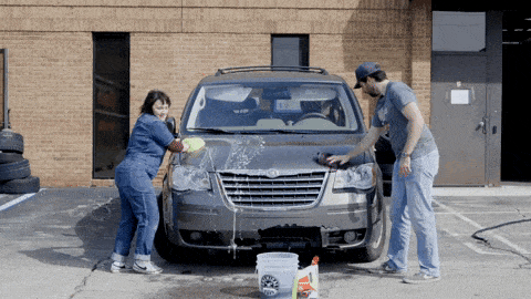 a man and woman washing a car