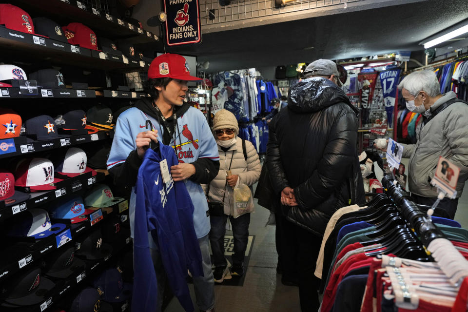 A store clerk, left, helps a customer choose items related to Shohei Ohtani of the Los Angeles Dodgers at SELECTION, a sporting goods store in Shinjuku district of Tokyo, Thursday, Feb. 29, 2024. (AP Photo/Hiro Komae)