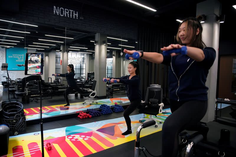 Fitness trainers Katie Xu and Heidi Liu lead exercise classes and stream them live at Pilates ProWorks studio in Shanghai