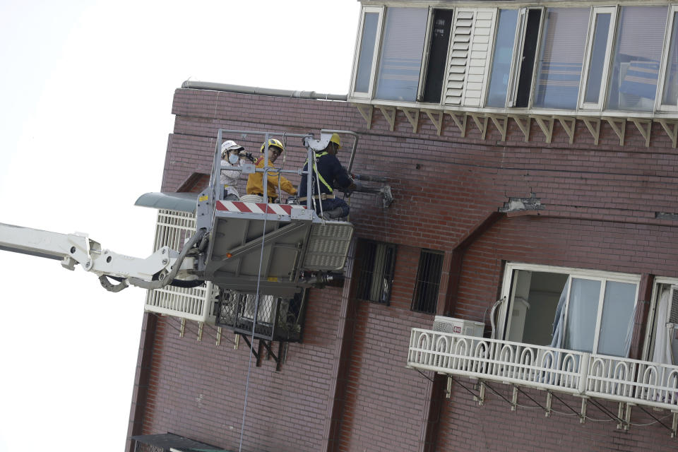 A structural engineer takes samples from a leaning building a day after a powerful earthquake struck, in Hualien City, eastern Taiwan, Thursday, April 4, 2024. (AP Photo/Chiang Ying-ying)