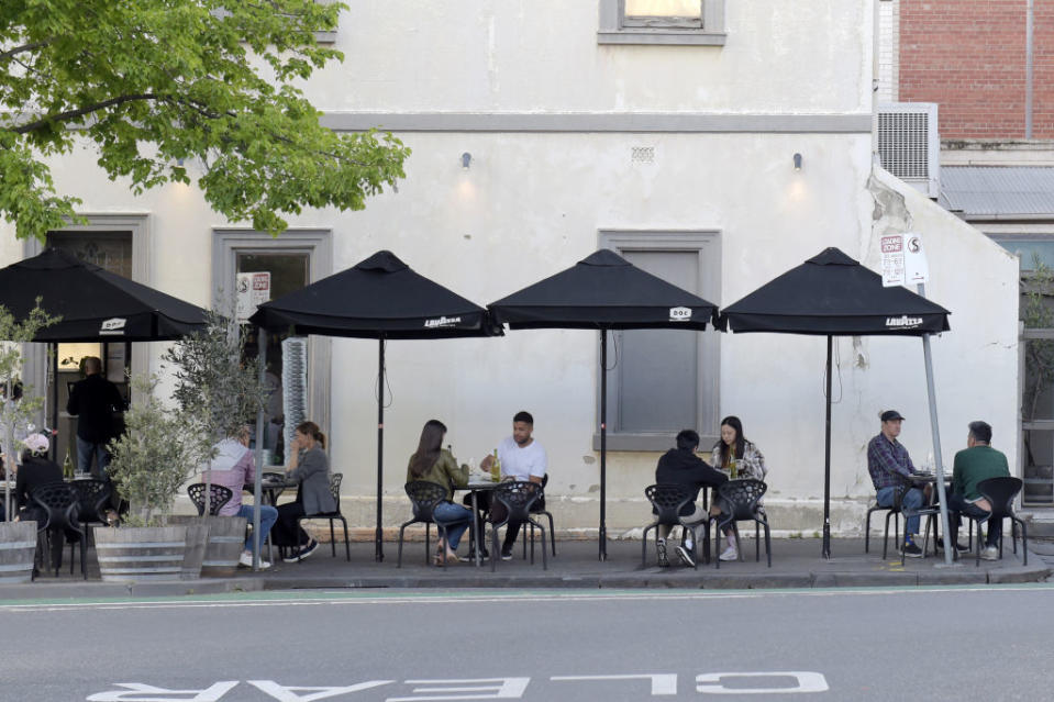 Customers sit at socially distanced tables outside a restaurant in the Carlton suburb of Melbourne.