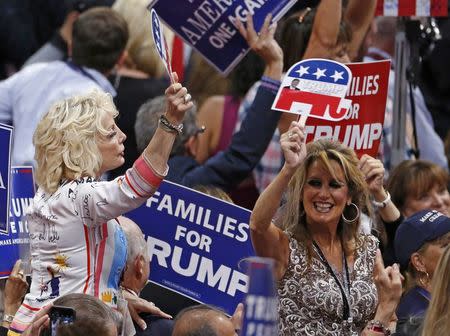 Women hold Trump signs at the Republican National Convention in Cleveland, Ohio, U.S., July 21 2016. REUTERS/Carlo Allegri