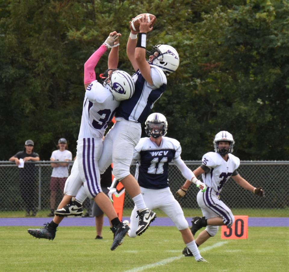 West Canada Valley's Sean Burdick makes a leaping interception over Ticonderoga Sentinel Nate LaCourse (left) during the first quarter of Saturday's game.