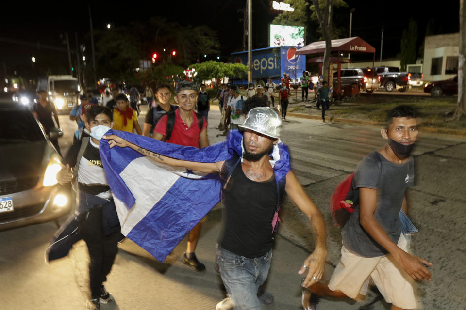 Migrants walk along a highway in hopes of reaching the distant United States, in San Pedro Sula, Honduras, Wednesday, Sept. 30, 2020. Hundreds of migrants have begun walking from this northern Honduras city toward the Guatemala border testing a well-trod migration route now in times of the new coronavirus. (AP Photo)