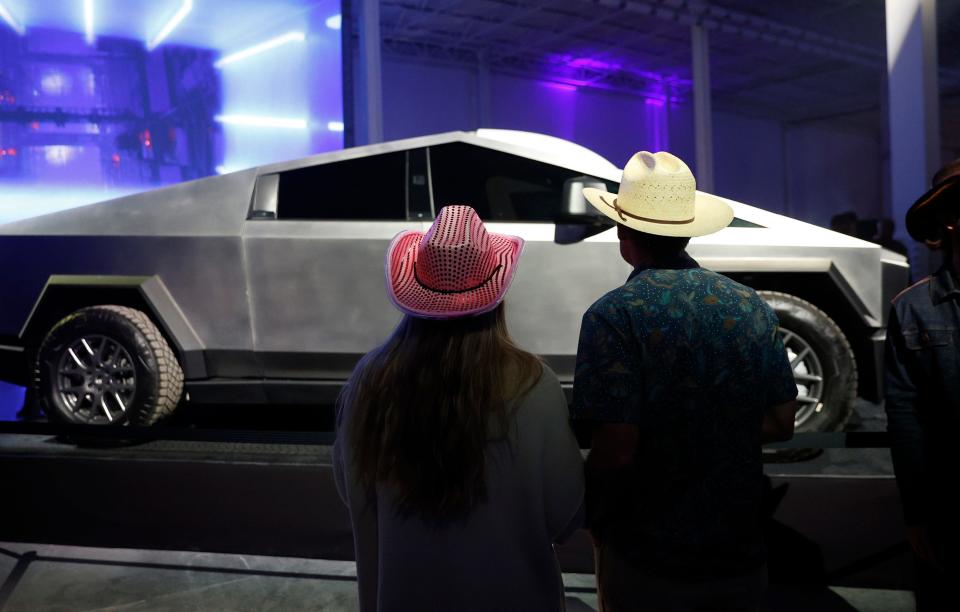 Guests look at a Tesla Cybertruck at the Cyber Rodeo grand opening celebration for the new $1.1 billion Tesla Giga Texas manufacturing facility on Thursday April 7, 2022.