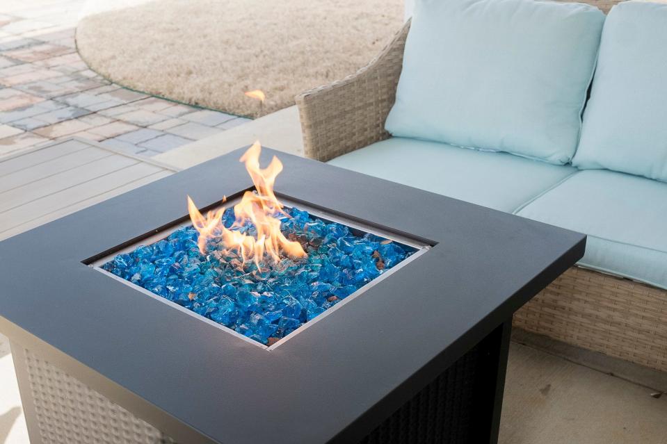 The seating area on the back patio features a gas fire pit.