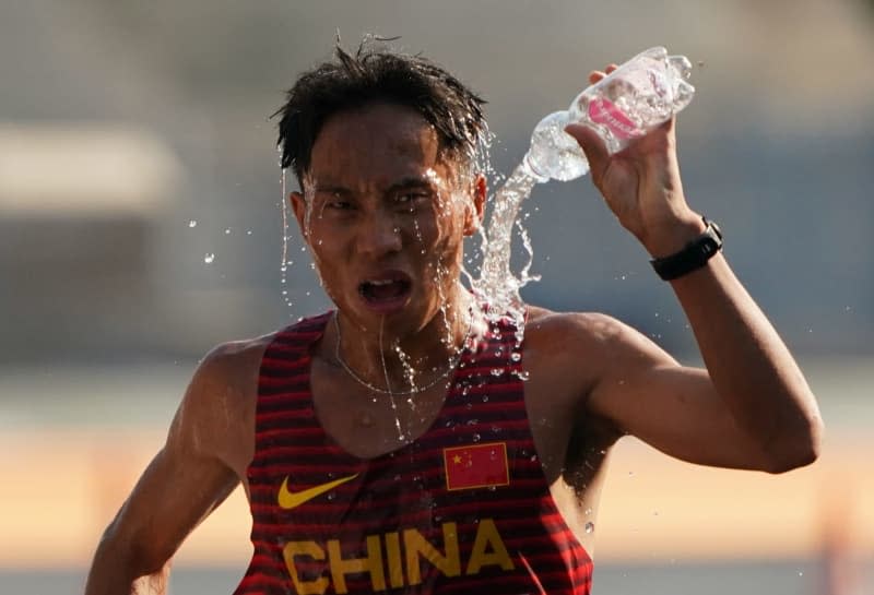 Chinese athlete Jie He pours water over his head during the Marathon of the World Championships. Marcus Brandt/dpa