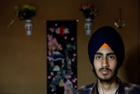 Gursewak Singh poses for a photographer in front of decorations on a wall at his house during an interview with Reuters, in Matsudo, Japan, September 25, 2016. REUTERS/Kim Kyung-Hoon