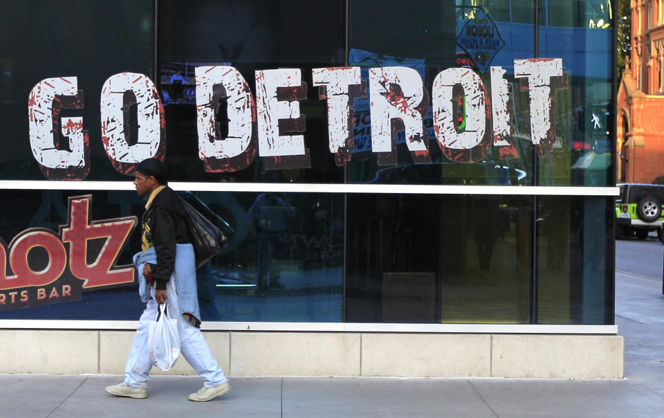 In this Oct. 24, 2012, photo, a pedestrian walks in Greektown in downtown Detroit. When baseball's World Series returns to Detroit this weekend for Game 3, television viewers will see vibrant crowds and skyline shots of the city. Yet beyond the hot dogs and home runs, Detroit is struggling to cross home plate. (AP Photo/Carlos Osorio)